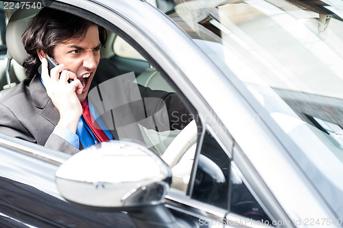 Image of Angry businessman shouting while driving