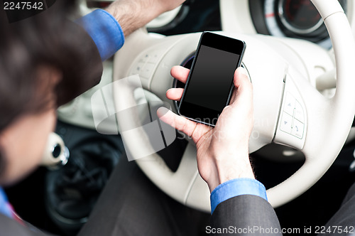 Image of Man using mobile phone while driving