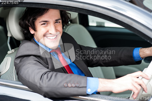 Image of Young businessman driving his car