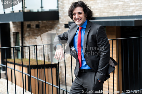 Image of Smart male professional posing casually, outdoors