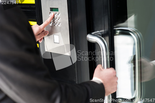 Image of Man entering security code to unlock the door