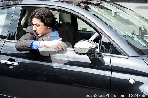 Image of Handsome man parking his new car safely