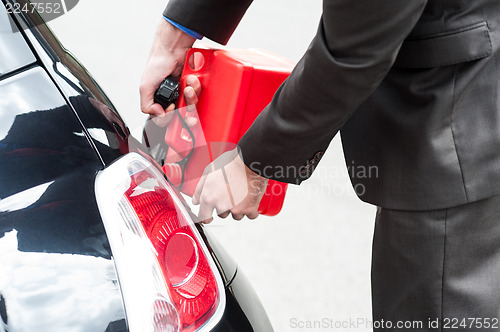 Image of Man refueling his car