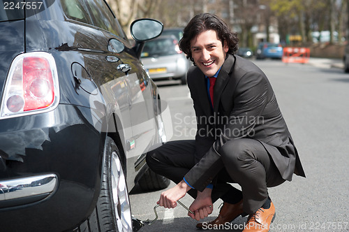 Image of Businessman repairing car roadside
