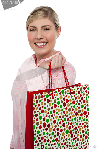 Image of Cheerful blonde girl holding shopping bag