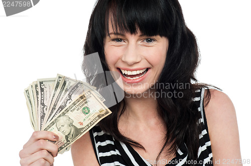 Image of Attractive young girl holding currency fan