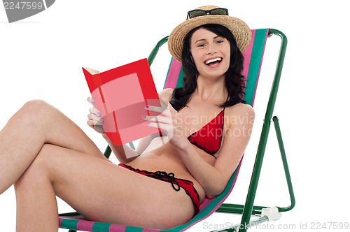 Image of Attractive bikini woman reading a book