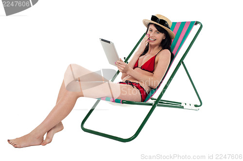 Image of Bikini woman holding touch screen tablet device