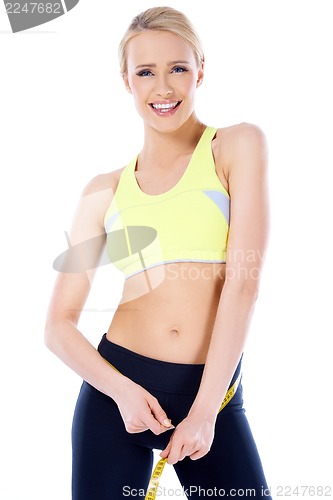 Image of Beautiful blond woman measuring her waist