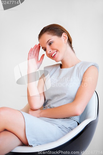 Image of Young attractive business woman sitting on chair