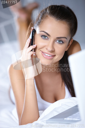 Image of Beautiful woman is resting on white bed