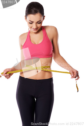 Image of Female athlete measuring her waist