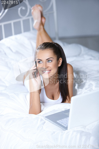 Image of Beautiful woman is resting on white bed