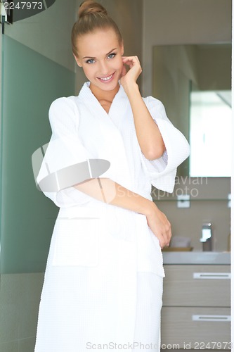 Image of Relaxed woman standing in white bathrobe