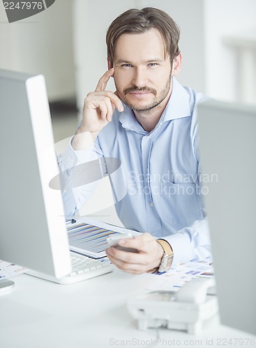 Image of Businessman sitting in front of computer monitors