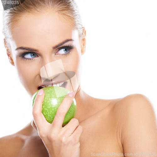 Image of Woman tries to bite a fresh green apple