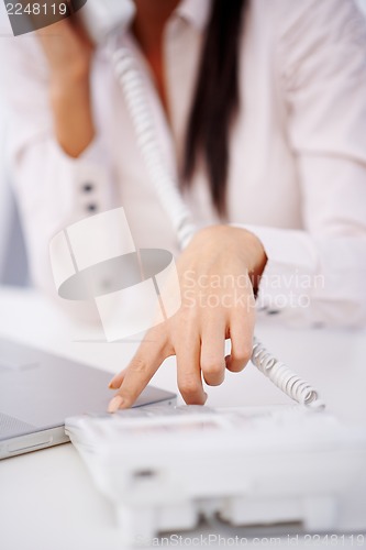 Image of Close up of a woman dialing on telephone