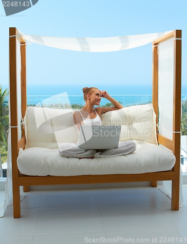 Image of Woman with laptop on canopied seat