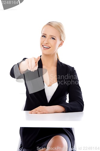 Image of Sexy blond business woman sitting in front of desk