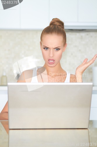 Image of Woman looking at laptop in horror