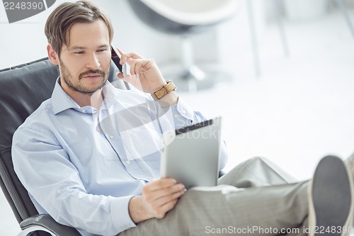 Image of Relaxed businessman talking mobile phone