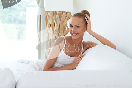 Image of Young beautiful woman sitting on couch