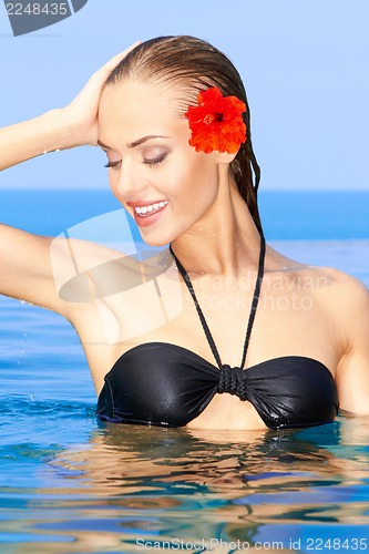 Image of Woman with red flower in swimming pool