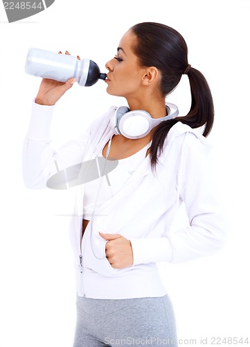Image of Sporty woman drinks from fitness bottle