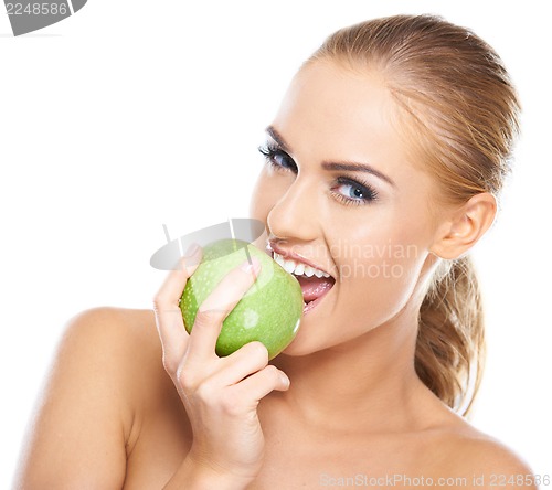 Image of Beautiful  young woman bites a green apple
