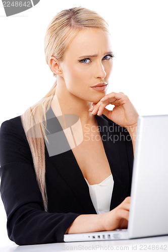 Image of Serious blond business woman working on computer