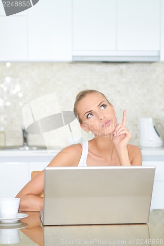 Image of Thinking woman sitting at laptop computer