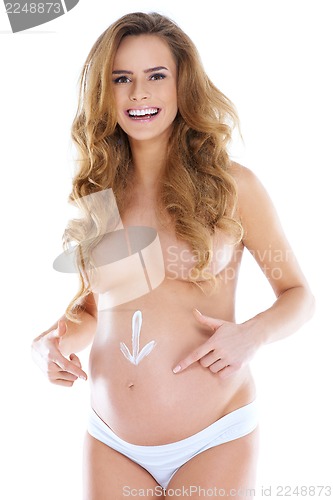 Image of Young pregnant woman with arrow shape pained