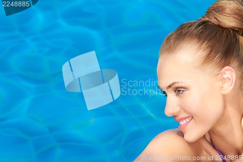 Image of Portrait of smiling beauty on blue water background