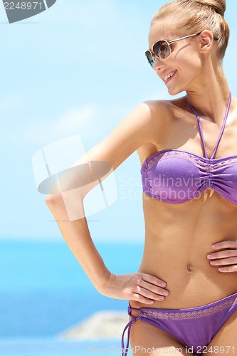 Image of Pretty female with sunglasses on at the pool