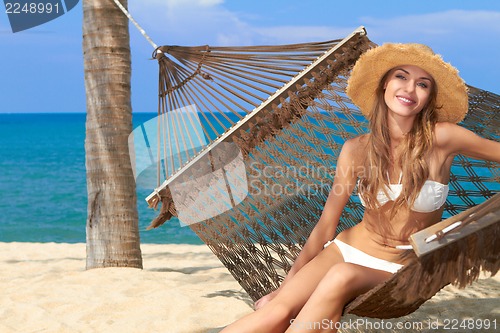 Image of Smiling female with a hat on beautiful beach