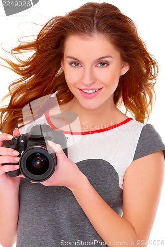 Image of Woman in gray dress wit digital camera on white
