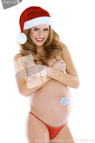 Image of Young happy pregnant woman wearing santa hat