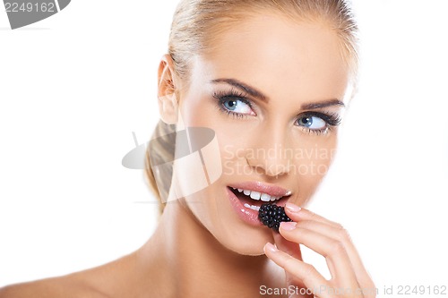 Image of Close up of beautiful woman eating blackberries