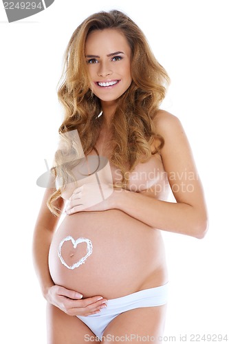 Image of Young pregnant woman with heart shape pained