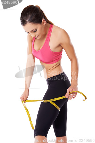 Image of Strong female athlete measuring her thigh