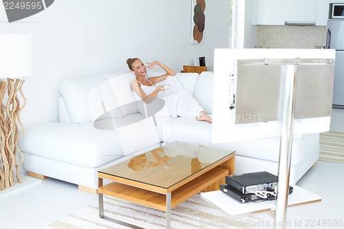 Image of Beautiful woman watching tv in home indoor