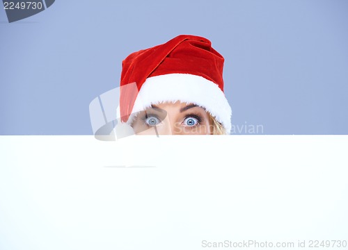 Image of Woman head and eyes with Santa hat above white board