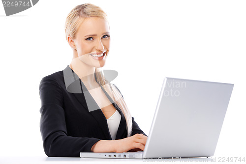 Image of Cute blond business woman working on laptop