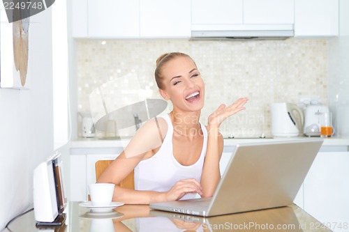 Image of Laughing woman sitting at laptop computer