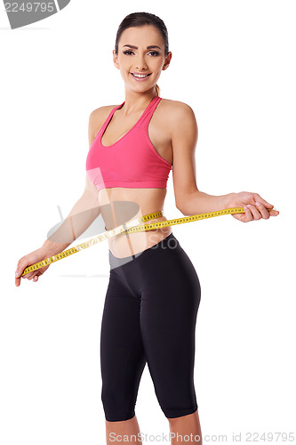 Image of Happy slim woman measuring her waist