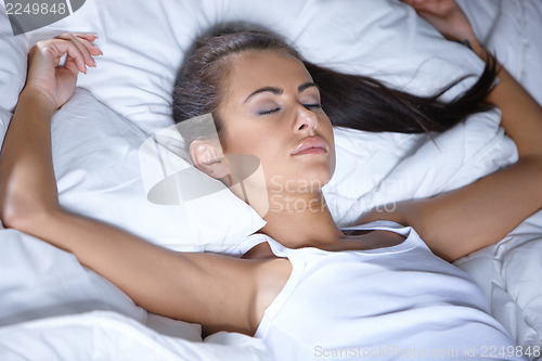 Image of Beautiful woman is resting on white bed