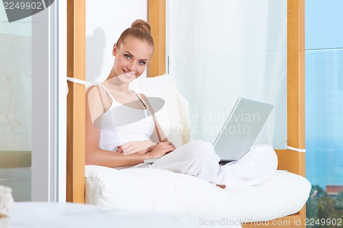 Image of Joyful woman laughing with laptop