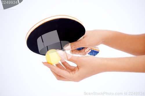 Image of Hands holding table tennis rocket and ball