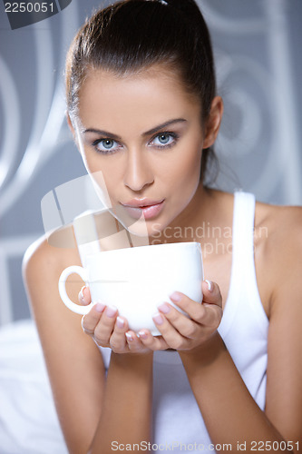 Image of Beautiful woman is resting on white bed
