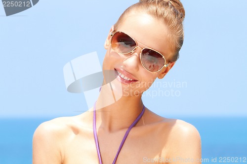 Image of Pretty woman at the beach with sunglasses